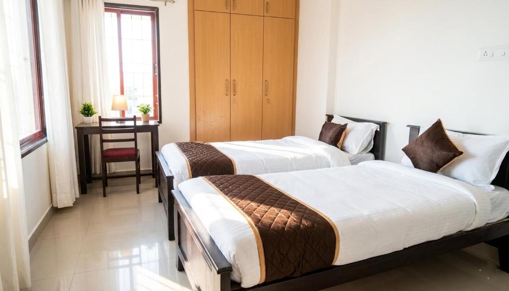 two beds in a room with a table and a window at Starlight Hotels OMR Thoraipakkam in Chennai
