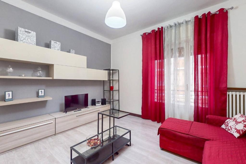 a living room with red curtains and a red couch at [AltaVista] Acqui sotto, cielo sopra il letto in Acqui Terme
