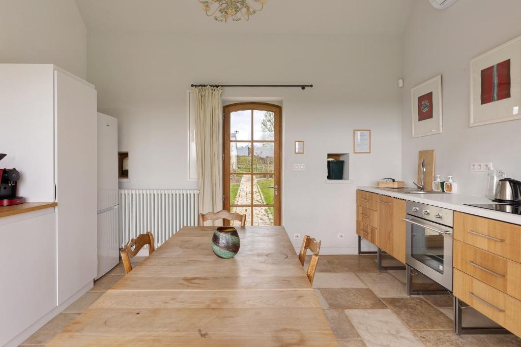 a kitchen with a wooden table in a room at Petit Prépinson - La Trigalière in Ambillou