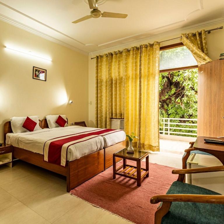 a bedroom with a bed and a large window at Theap Hospitality Enterprises in Noida