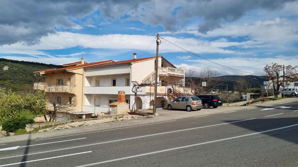 a building on the side of a road with cars parked at Apartments Josip 2830 in Rab