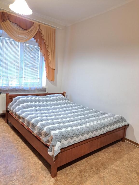 a bed sitting in a room with a window at Квартира Шевченка in Lutsk