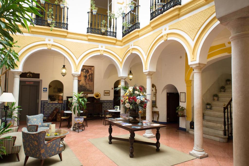 ein Zimmer mit einem Tisch mit Blumen darauf in der Unterkunft Hotel Abanico in Sevilla