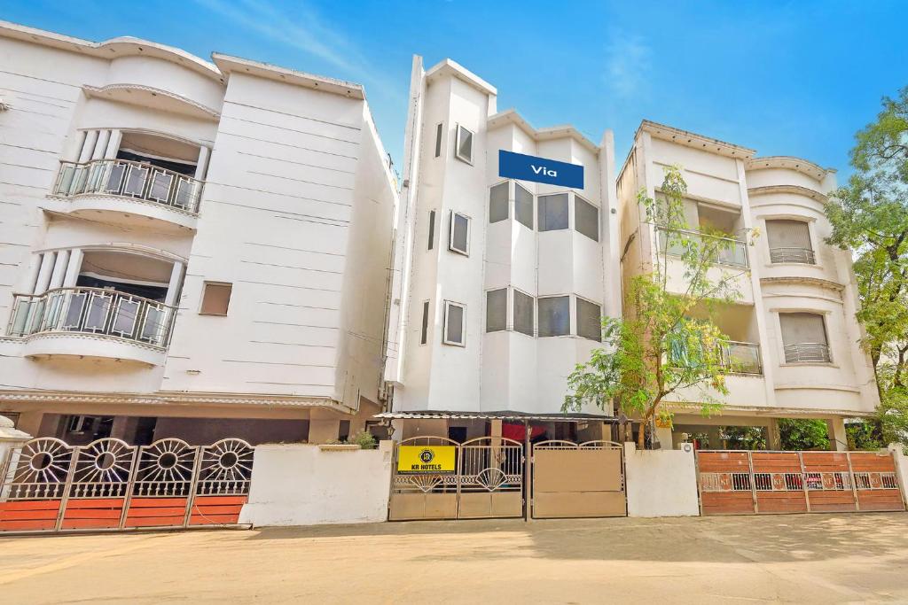 a white building with a blue sign on it at Via KR in Chennai
