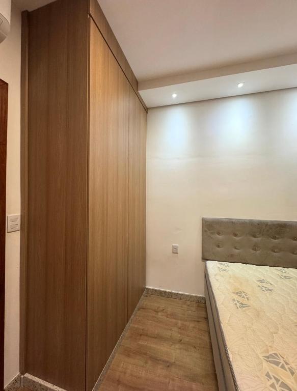 a bedroom with a bed and a wooden wall at STUDIO Flat B in Betim