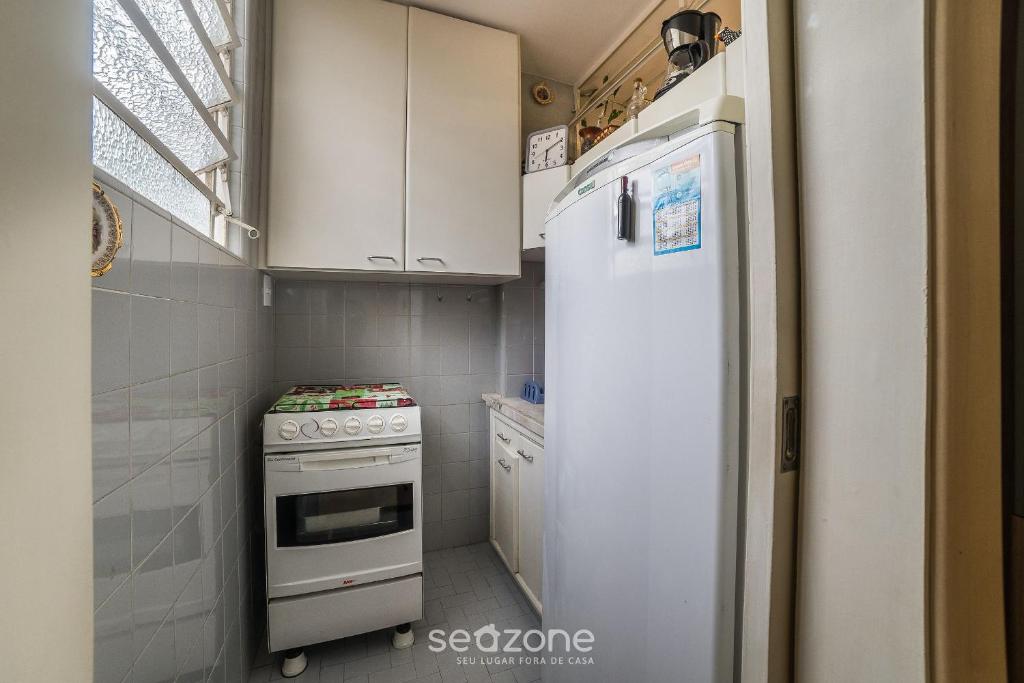 a small kitchen with a white refrigerator and a stove at Studio in Condo w/ Pool in Downtown QUI0605 in Poços de Caldas