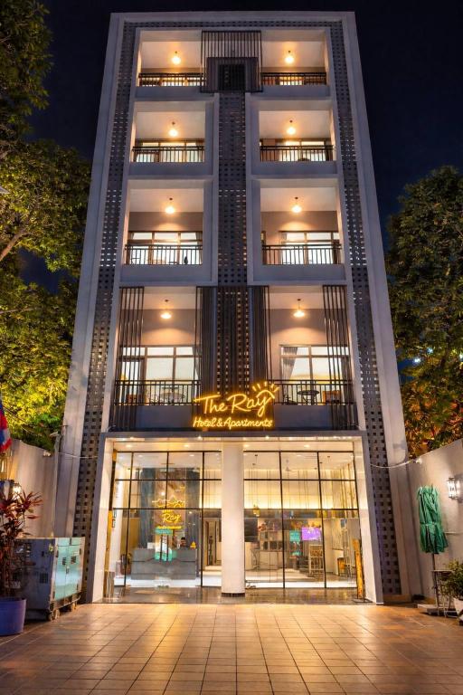 a tall building with a lit up sign in front of it at The Ray Hotel & Apartments in Phnom Penh