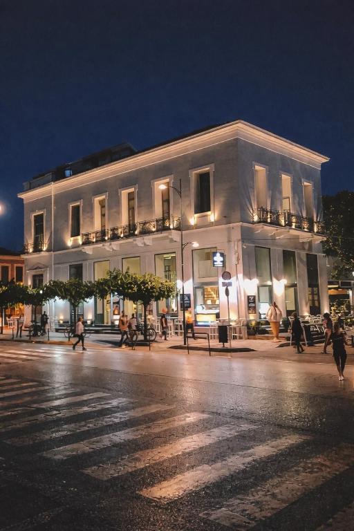 a large white building with people walking in front of it at Panellinion Luxury Rooms in Kalamata