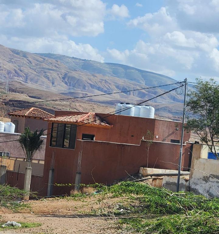 a house with a mountain in the background at Ranachalet-1 in Ash Shāghūr