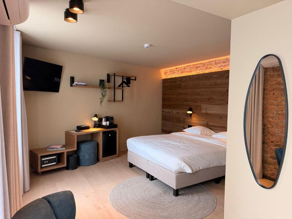 a bedroom with a bed and a mirror at Hotel Richmond in Blankenberge