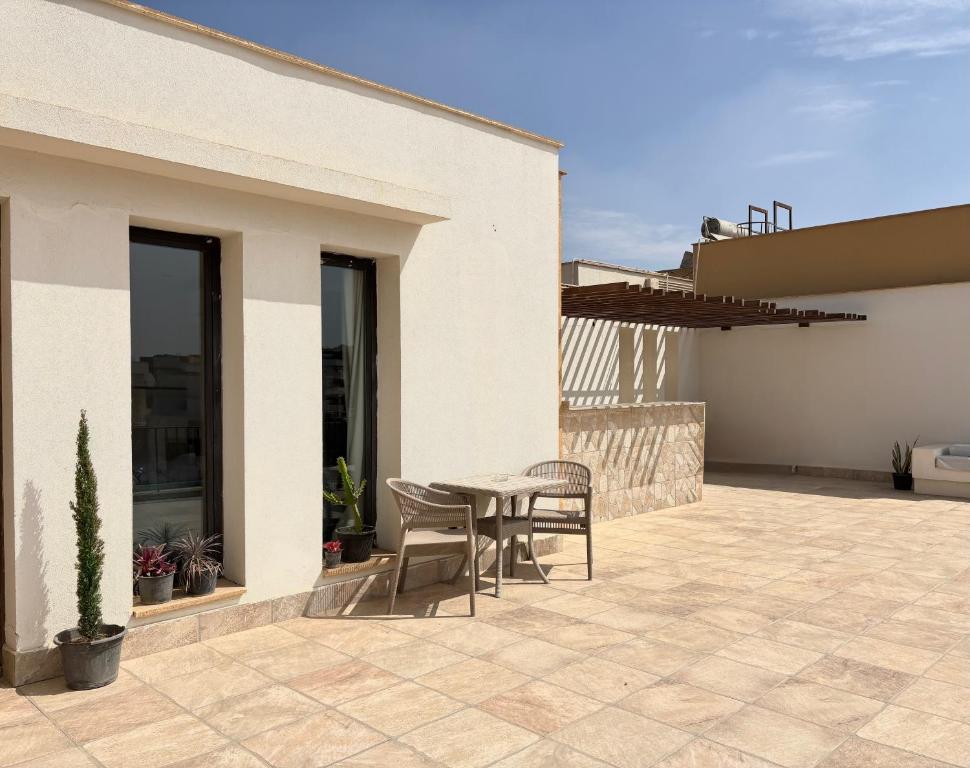a patio with a table and chairs on a house at Modern Rooftop Studio in Westown, Sheikh Zayed - Near GEM & SPX Airport in Sheikh Zayed
