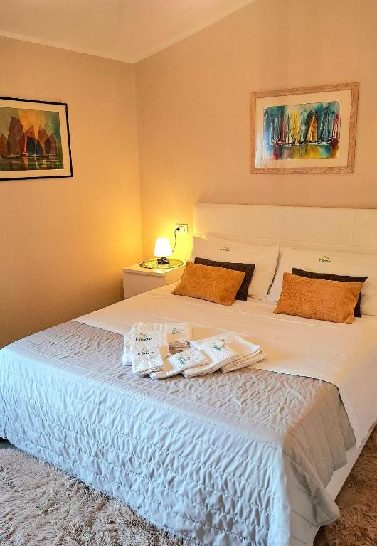 a bedroom with a large white bed with towels on it at Il limone in Gargnano