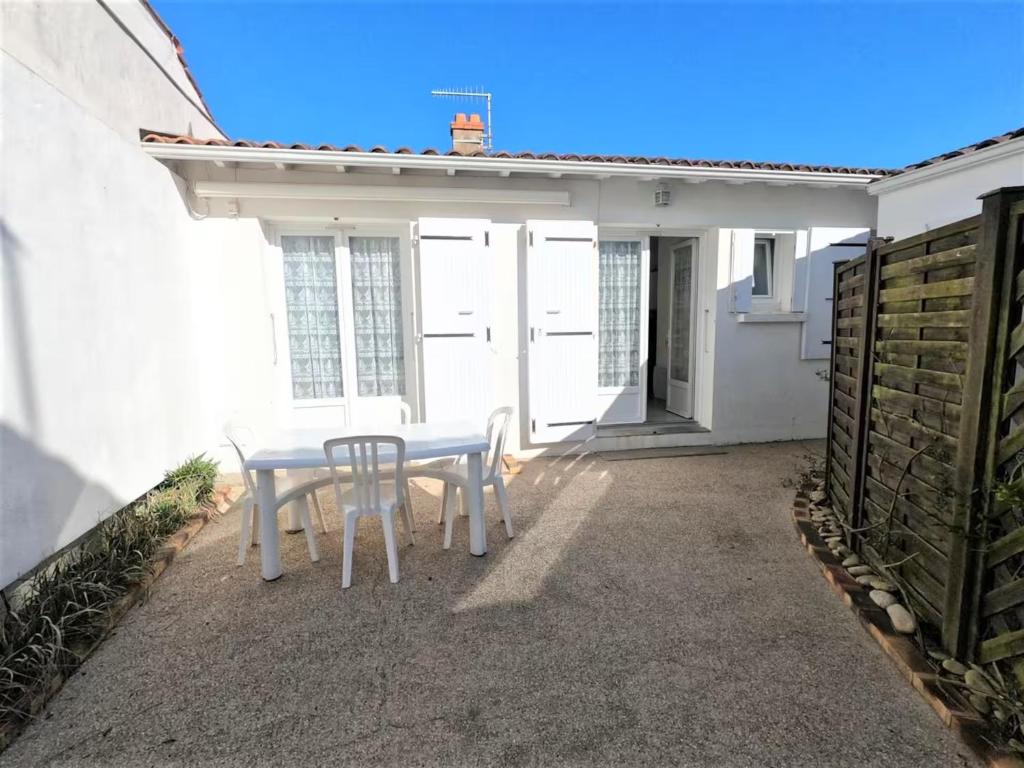 a white table and chairs on a patio at Maison du centre - ruelle calme in La Tranche-sur-Mer