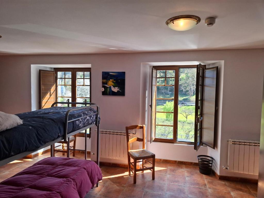 a bedroom with a bunk bed and two windows at Albergue Val de Samos in Samos
