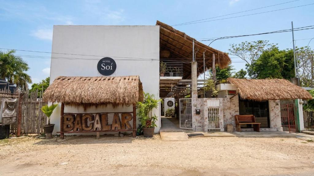 a small white building with a sign on it at HOTEL SOÍ BACALAR in Bacalar