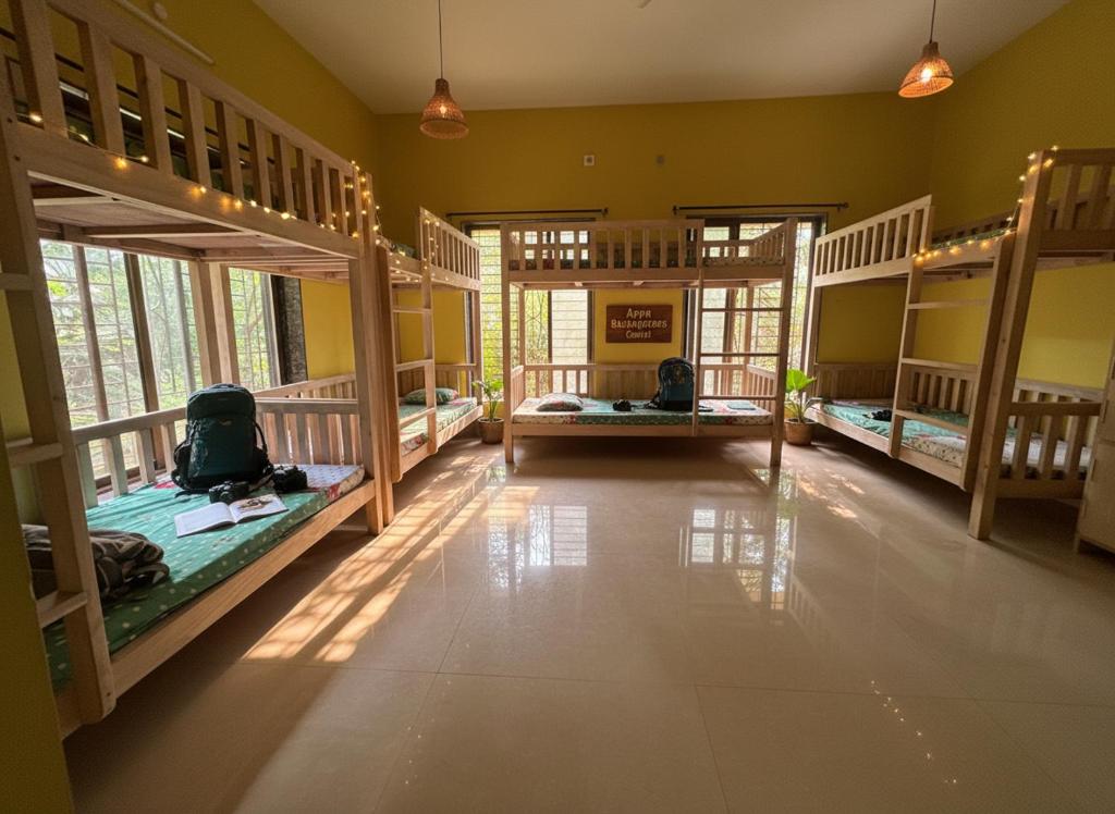 a large room with three bunk beds in it at Aapa's Backpackers Coastel in Malvan