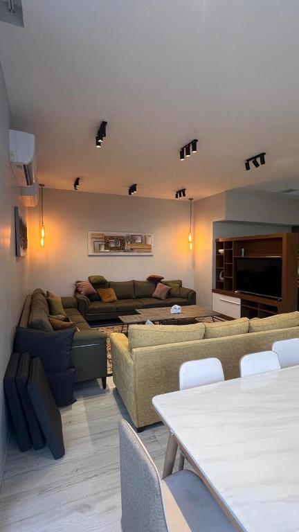 a living room with two couches and a tv at شالية موج 335 in Dhahran