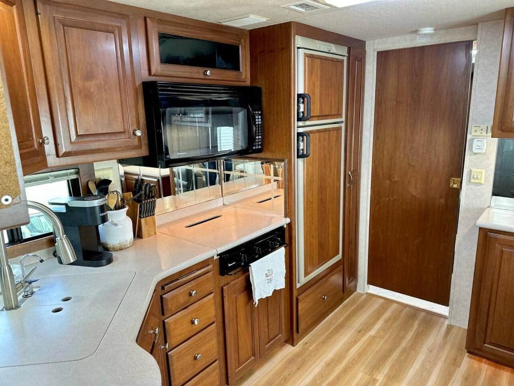 a kitchen with wooden cabinets and a microwave at Wilderness Retreat in Alba