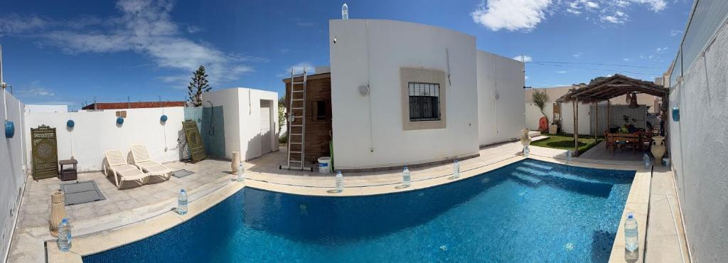 a house with a swimming pool next to a building at Villa Al-Qamar in Midoun
