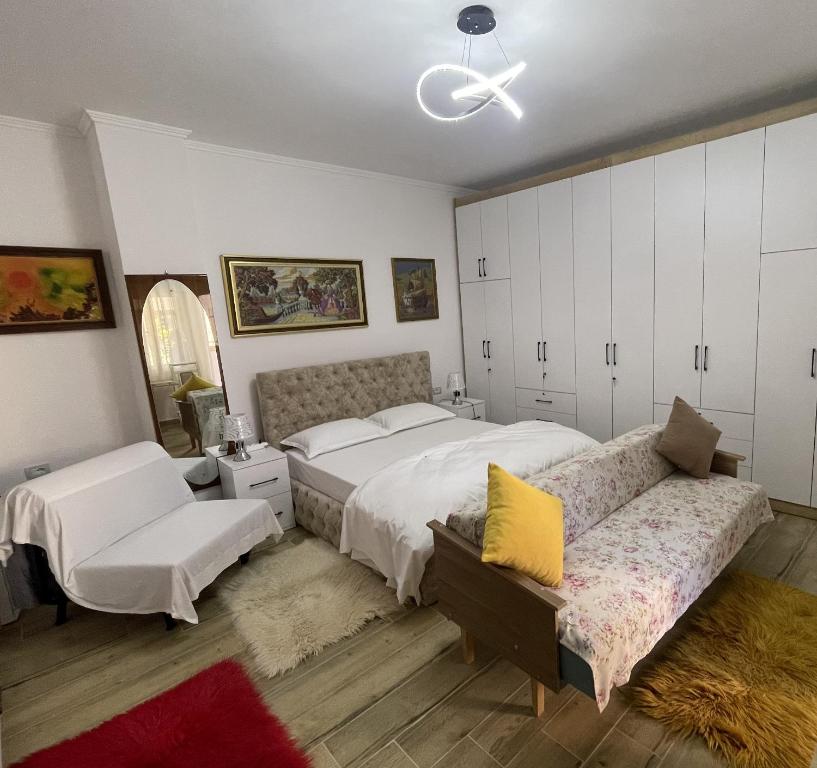 a bedroom with two beds and a couch at Cozy Riverside Apartment in Këlcyrë