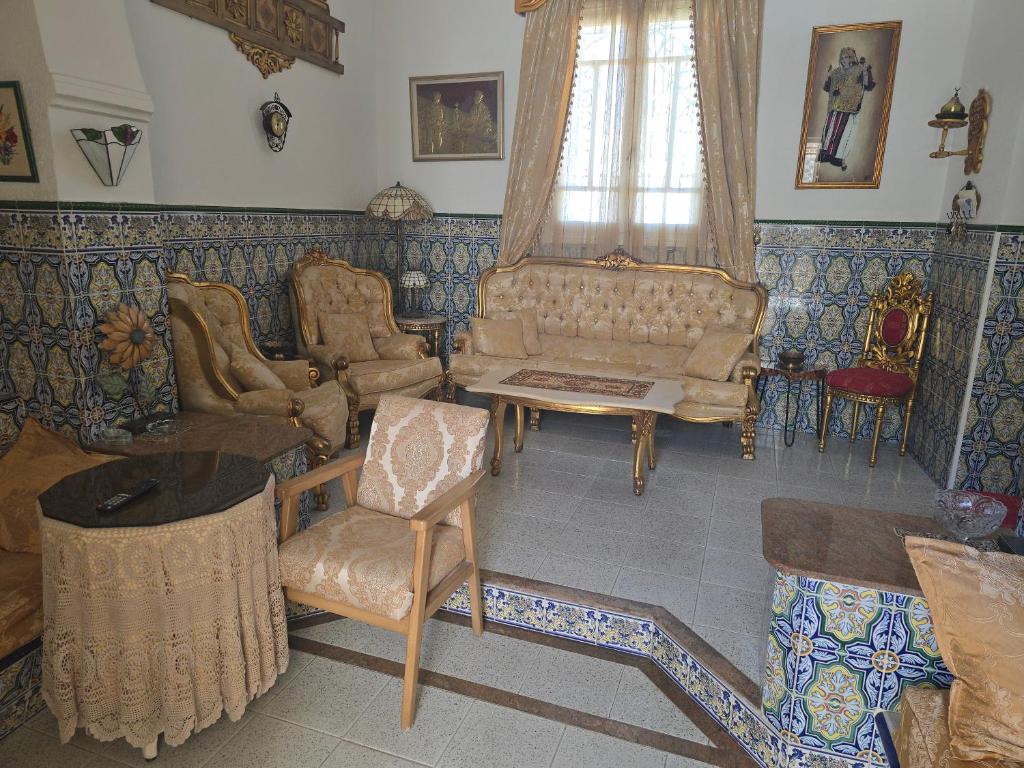 a living room with a couch and a chair at Dar lel khedija in Mahdia