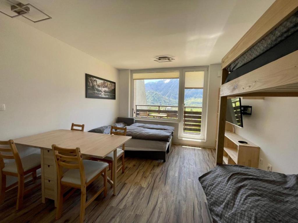 a room with a table and a bed and a bedroom at Studio Pod Kaninom in Bovec