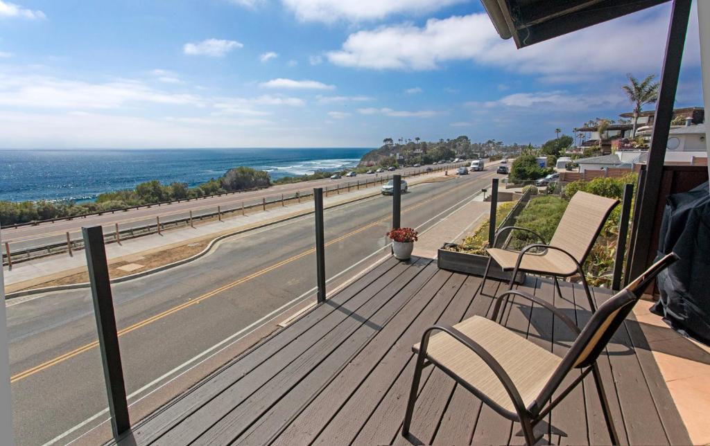 a balcony with two chairs and a road at Catch some waves! Panoramic ocean views!- Cardiff Surfer in Cardiff-by-the-Sea