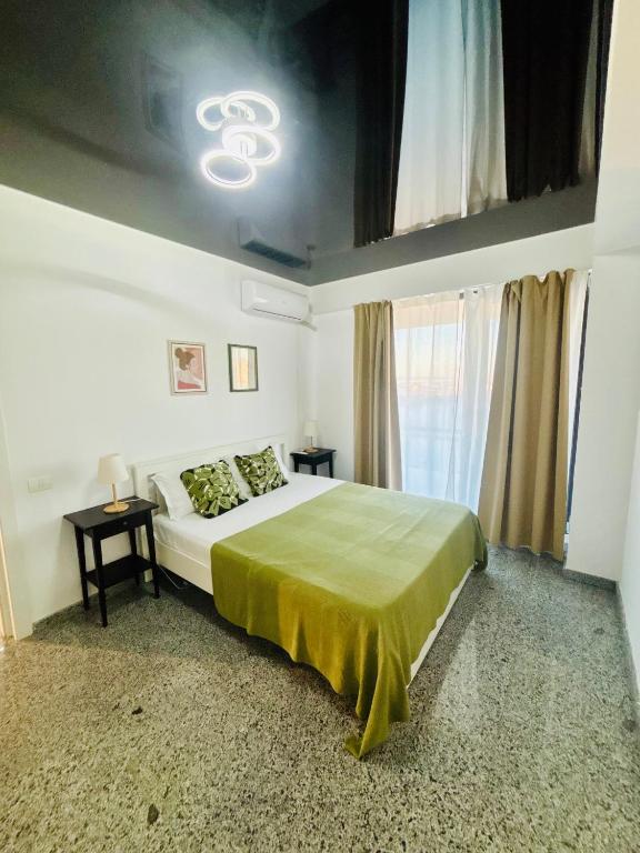 a bedroom with a bed with a green bedspread at B1 Apartments Deluxe in Năvodari