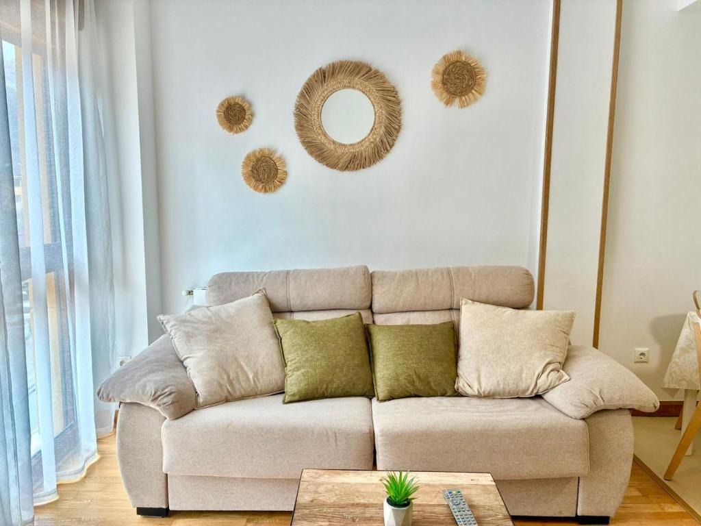 a living room with a couch and mirrors on the wall at El Descanso del Cares in Arenas de Cabrales