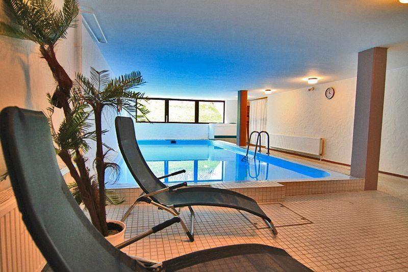 a swimming pool with a chair in a room with at RUeM-HART-I-Whg-2 in Hörnum
