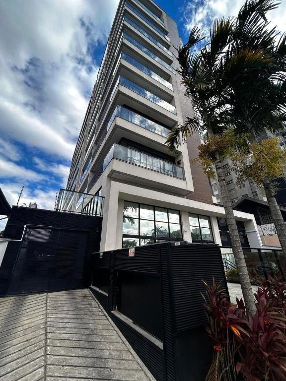 a tall building with a fence in front of it at RCM Vilas - Apartamento 306 in Joinville