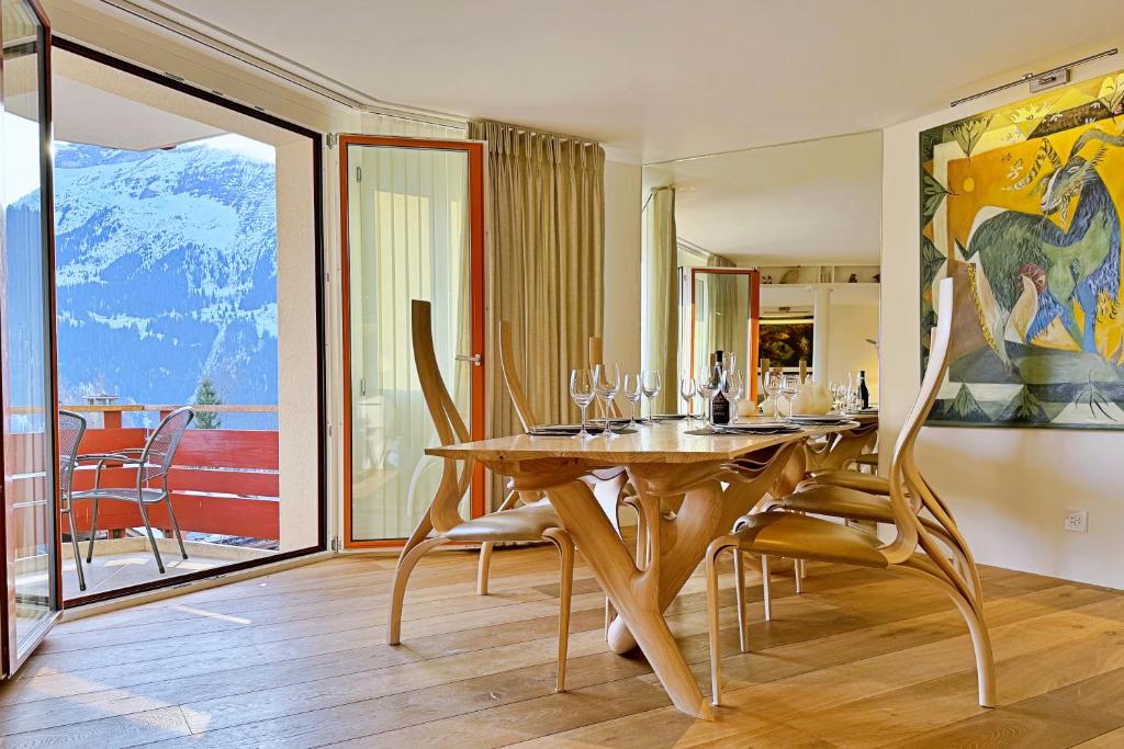 a dining room with a wooden table and chairs at Eiger Residence 2 in Wengen
