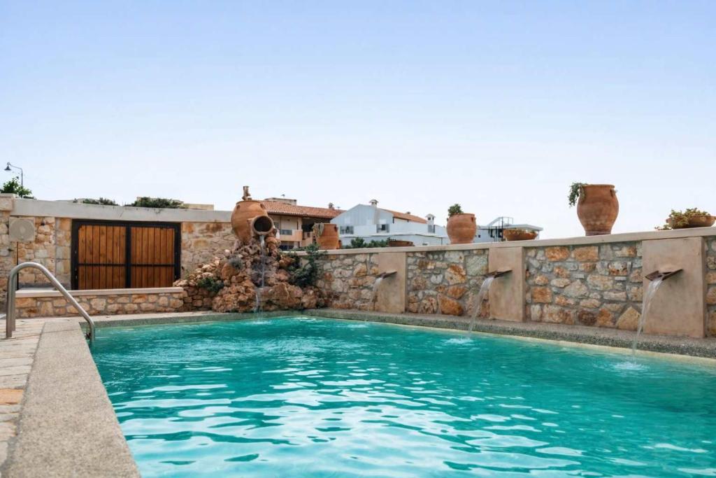 a swimming pool with a stone retaining wall and a swimming pool at Vertigo Stone Villa - Roumeli Private Pool Escape in Roumelí