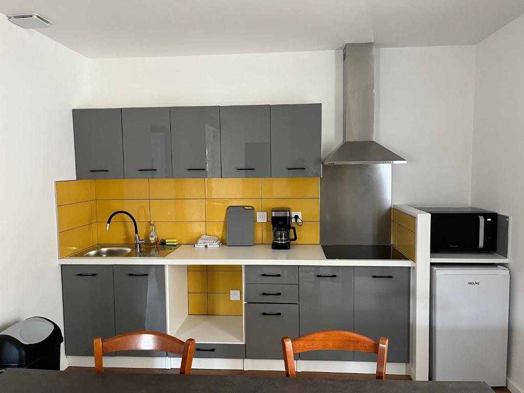 a kitchen with two chairs and a sink at Les gîtes de Mazélise in Mazerolles