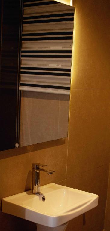 a bathroom sink with a mirror and a window at Emerald Apartments in Lagos
