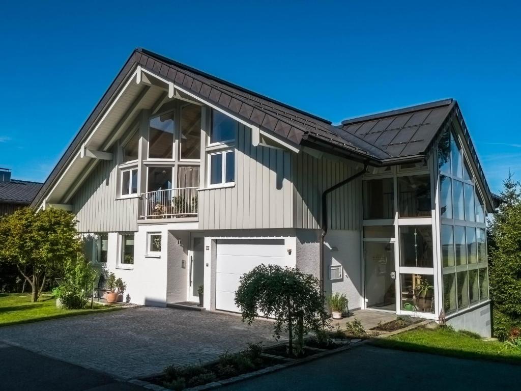 ein Haus mit einem Gamer-Dach und einer Garage in der Unterkunft Maly´s Ferienwohnung in Sulzberg