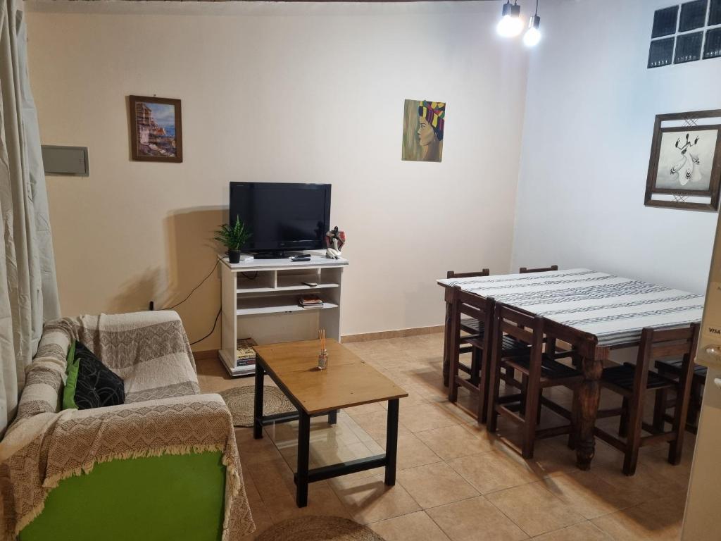 a living room with a table and a television at Refugio del Valle - Uspallata in Uspallata