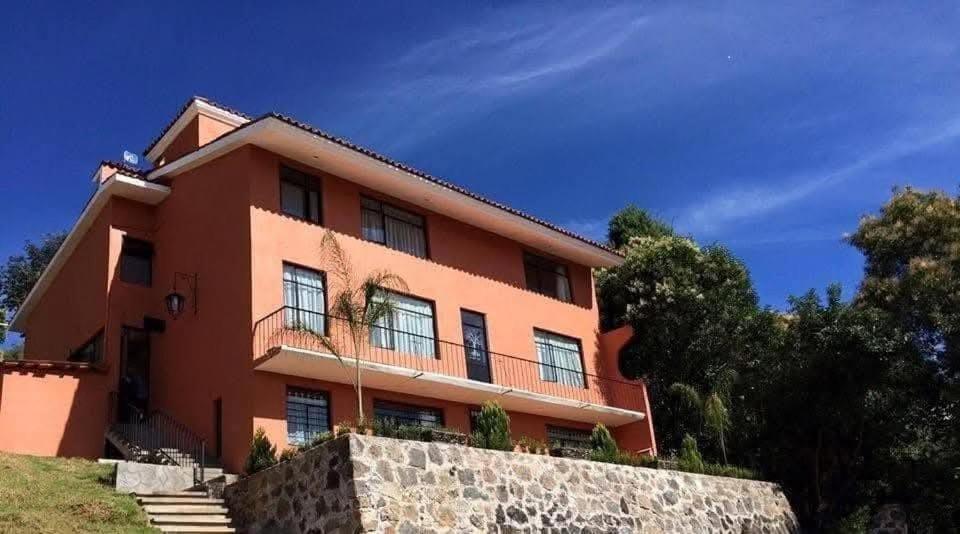 a large orange house with a stone wall at Casa Amelia Hotel & Boutique in Zacatlán