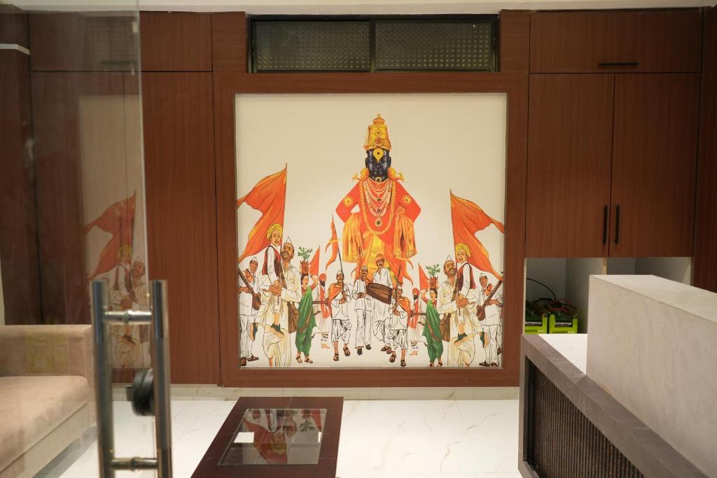 a painting on a wall in a room at Shri Prasad Executive in Pandharpur
