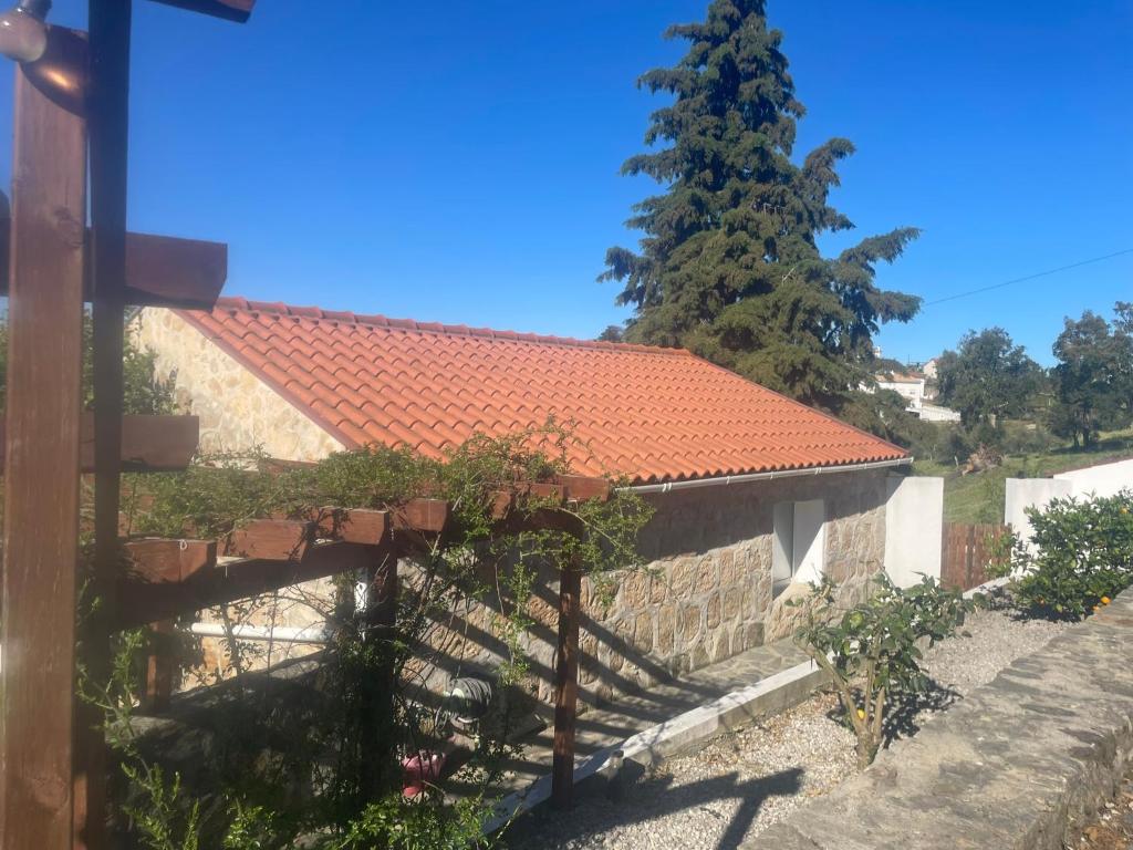 a house with a red roof and a tree at Casa Água in Lamas