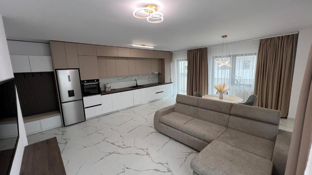 a living room with a couch and a kitchen at Apartament excepțional Ramona in Râmnicu Vâlcea