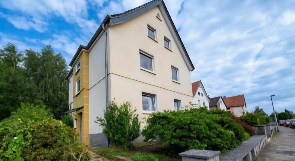 a large white house with yellow trim at Ruhiges und gemütliches Appartment mit Garten in Herford