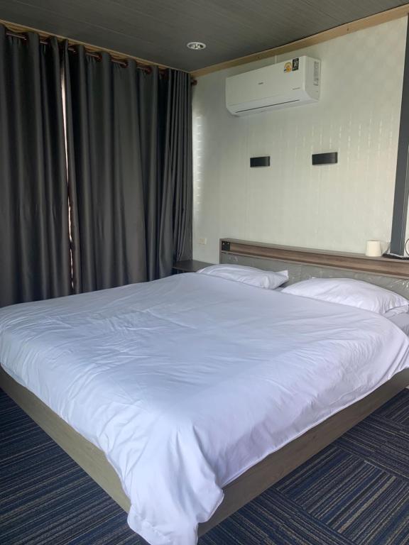 a bedroom with a large bed with white sheets at Tawan Resort in Bophut