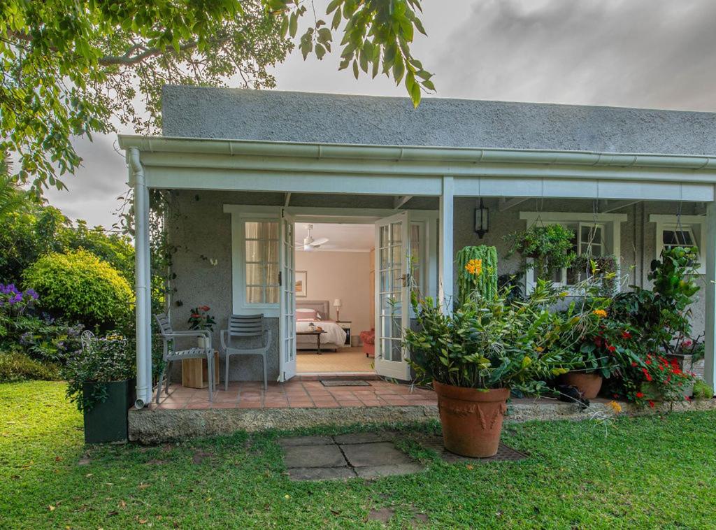a small house with a patio with plants at Lloyd Road Cottage in Port Elizabeth