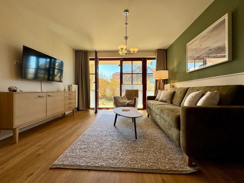 a living room with a couch and a table at Oewern Diek App 52 in Wustrow