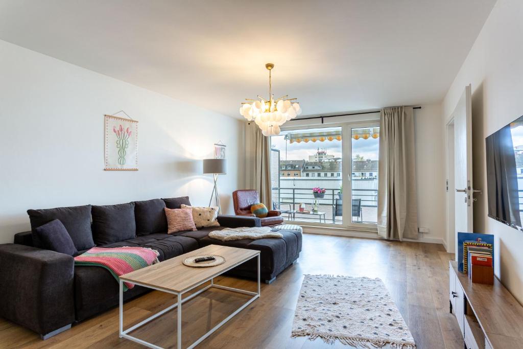 a living room with a couch and a table at LEVEL22 ! Groß & Modern, Parkplatz, Balkon, Küche in Leverkusen