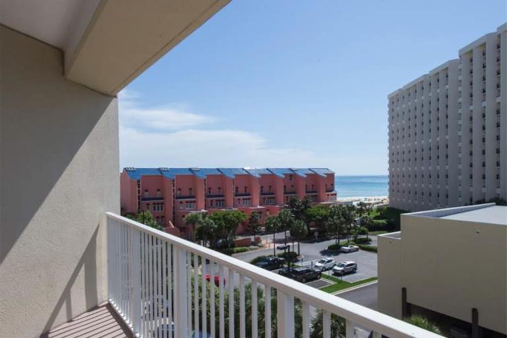 a balcony with a view of a building and the ocean at Beachfront Condo with Balcony Pools and Gym in Destin
