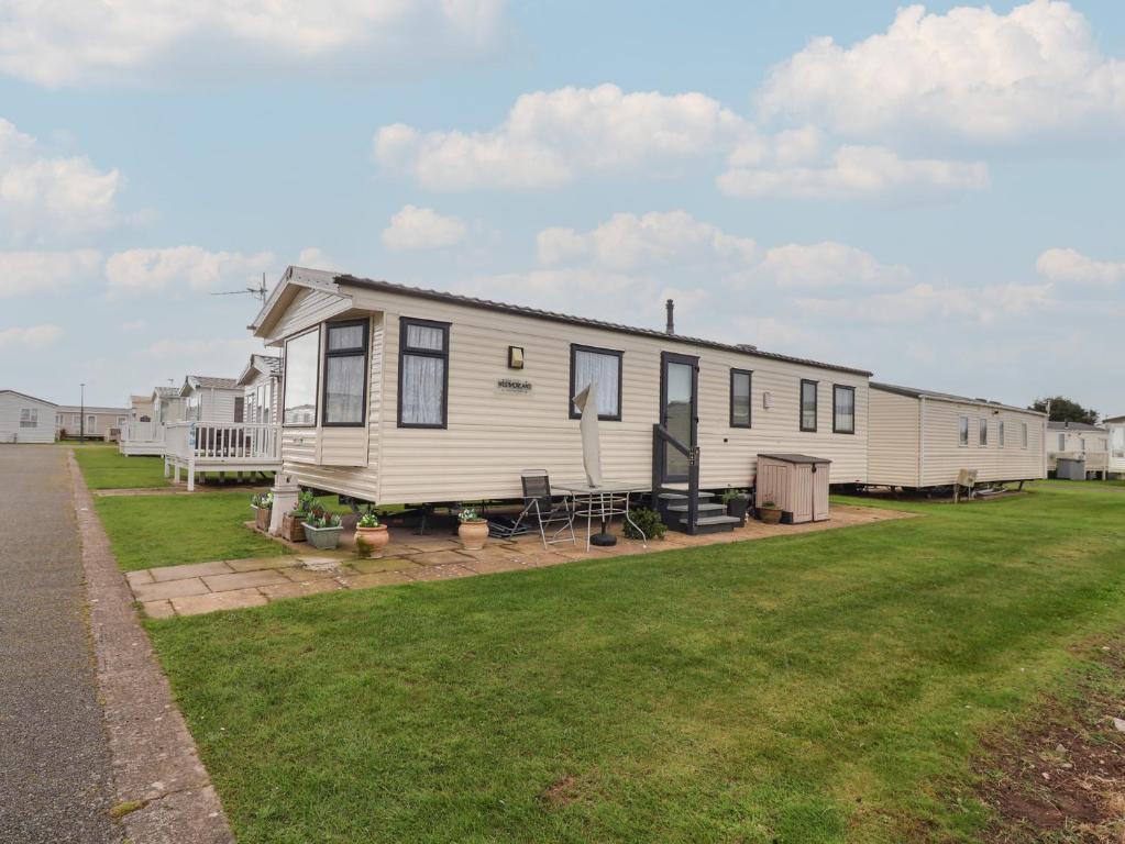 a large white mobile home on a lawn at Winchester - 244 in Rhyl