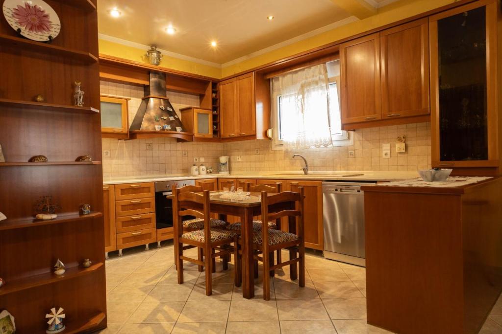 a kitchen with wooden cabinets and a table and chairs at mastic flavored sweet in Chios