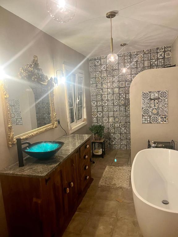 a bathroom with a blue sink and a tub at B&B by the River Beach in Mega Fundeira